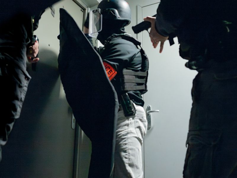 © William Keo - Men from the anti-crime brigade prepare to break down a door to arrest a man presumed to be a drug lord.