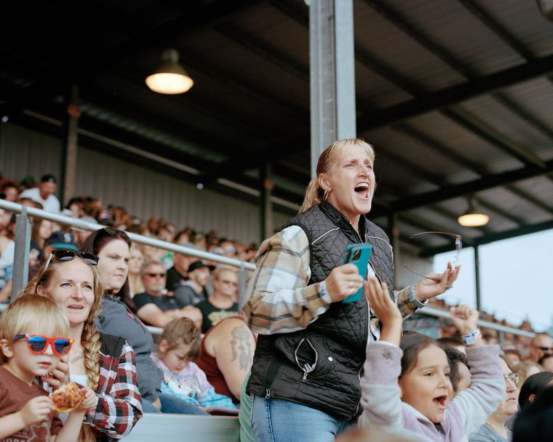 © Marco Waldis - Joyce Bos cheering from the stands for her sons at the demolition derby during the annual county fair.