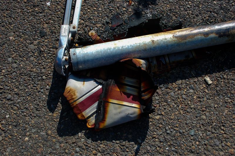 © Erin McMillen Gustafson - Scraps of charred and red striped awning still attached to it's poles.
