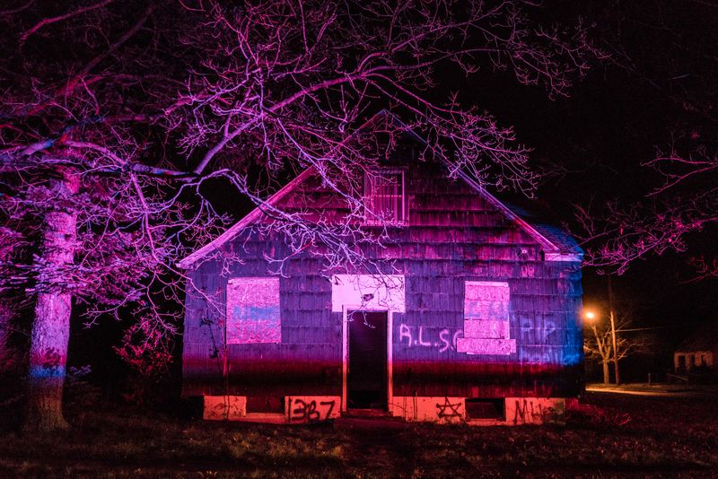 © Zackary Canepari - Police lights from a nearby homicide investigation illuminate a vacant home in North Flint Michigan.