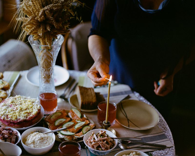 © Anya Tsaruk - My grandmother Maria lights a candle on the Christmas table.