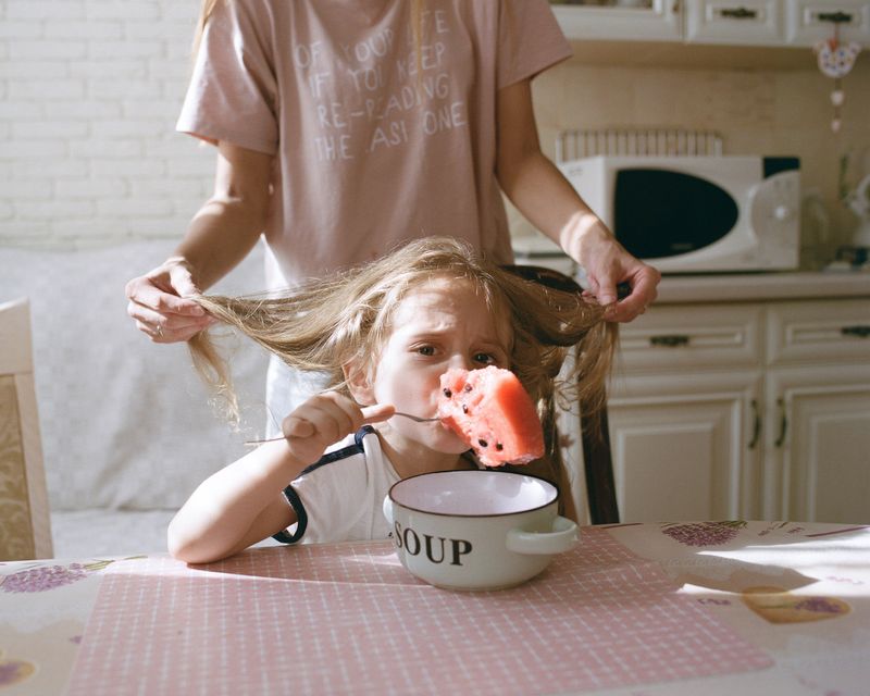 © Anya Tsaruk - My cousin Maksym eats watermelon while his mother, Ira, fixes his hair at their home in Khmelnytskyi.