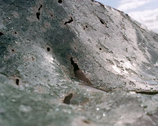 © Anya Tsaruk - The shattered windshield of a car destroyed by Russian shelling at the frontline.