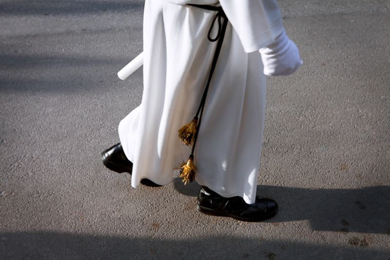 © Antonio Sansica - A component of the procession walks along the procession in the streets of Trapani.