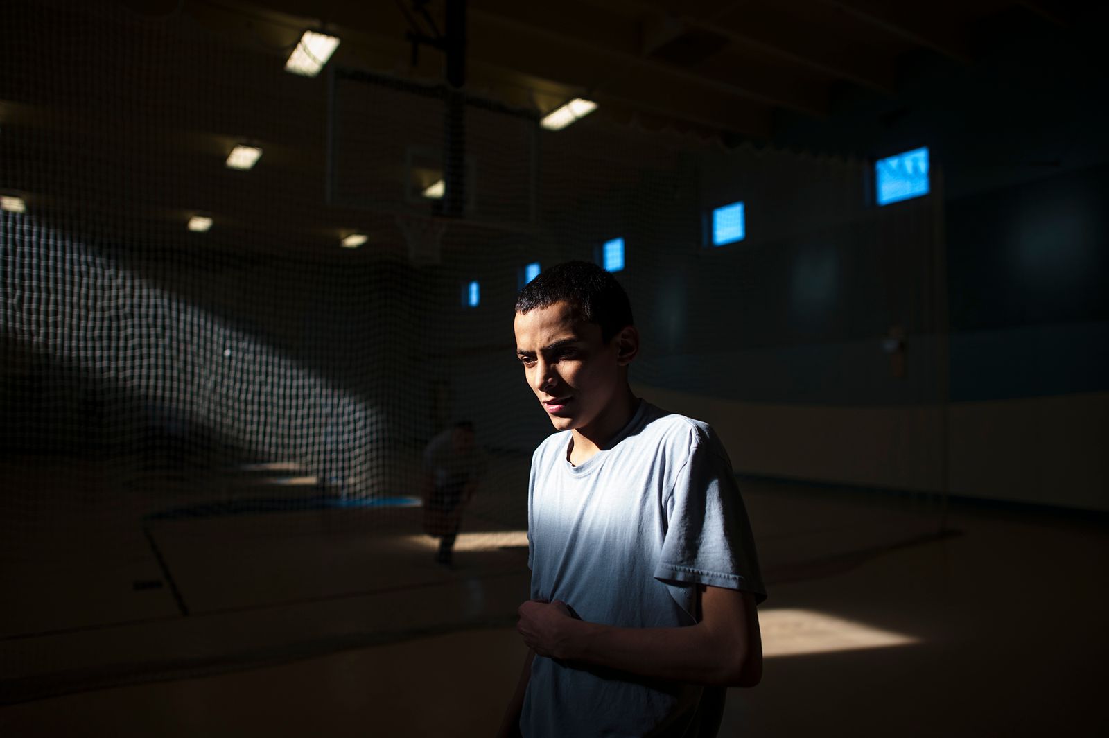© Isadora Kosofsky. Ramon, age 15, stands in the gym at the juvenile detention center in Albuquerque, New Mexico