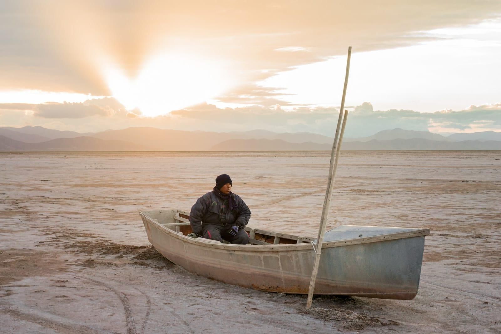© Misha Vallejo. Félix Sequeiros sits in his cousin's boat in the now-dry Lake Poopó in Bolivia