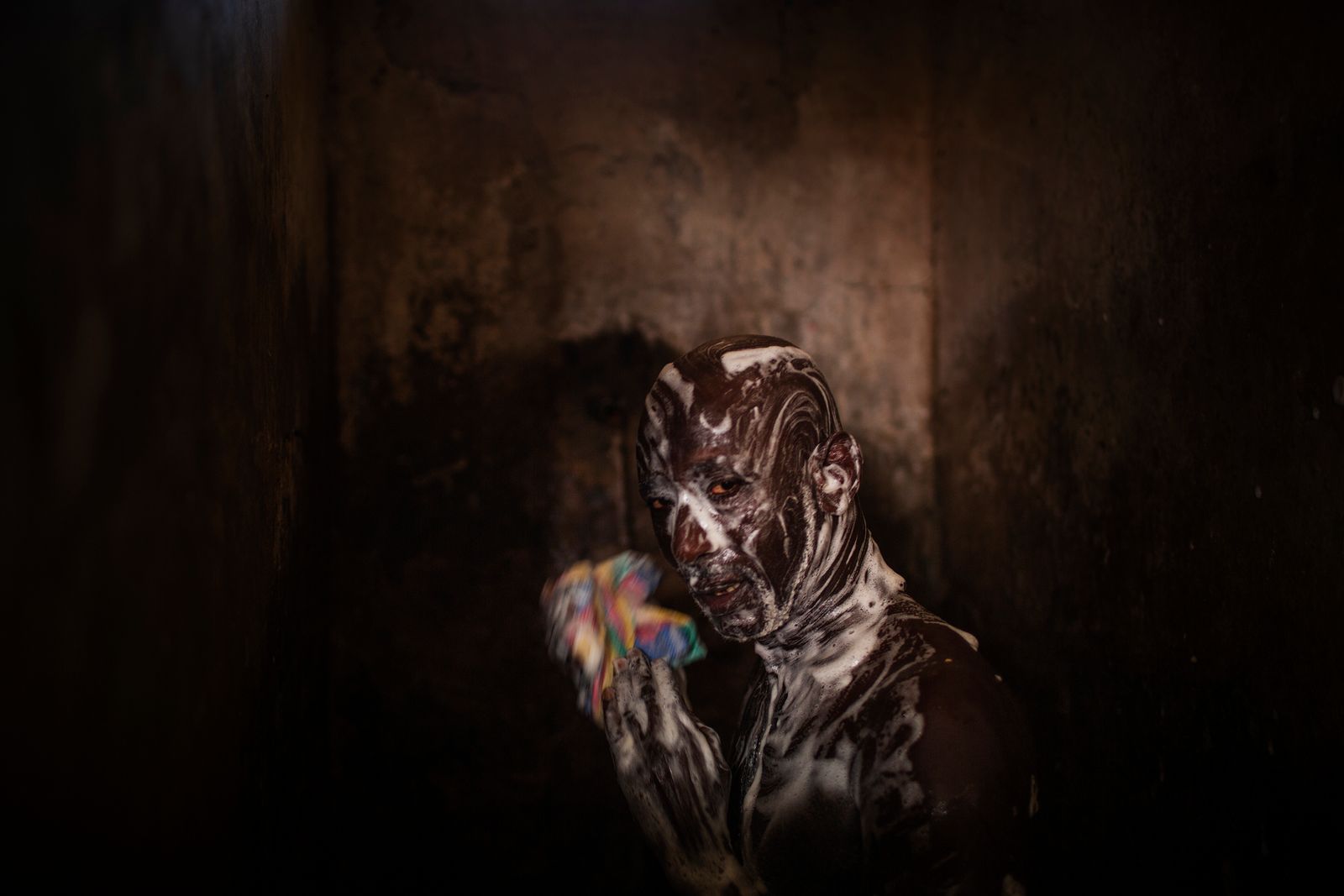 © Diego Ibarra Sánchez - Mile 2, Banjul: Remand prisoner takes shower inside the dilapidated shared bathroom at the remand wing.
