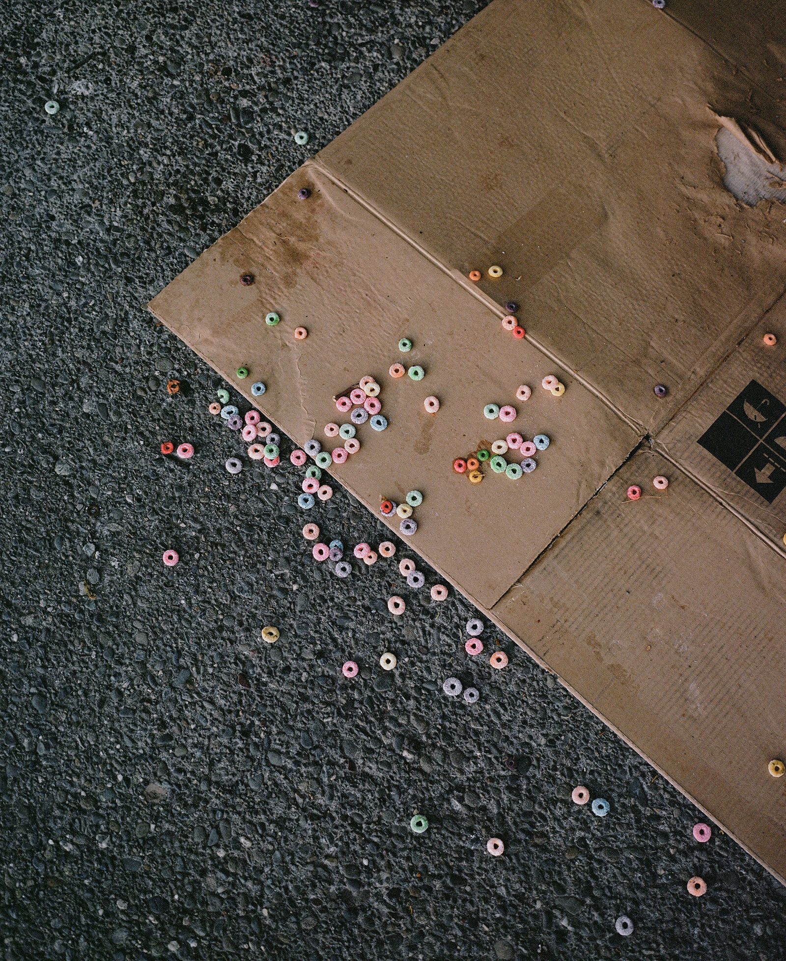 © Justin Maxon - Fruity Loops cereal is seen scattered on cardboard near where a houseless person was previously sleeping.