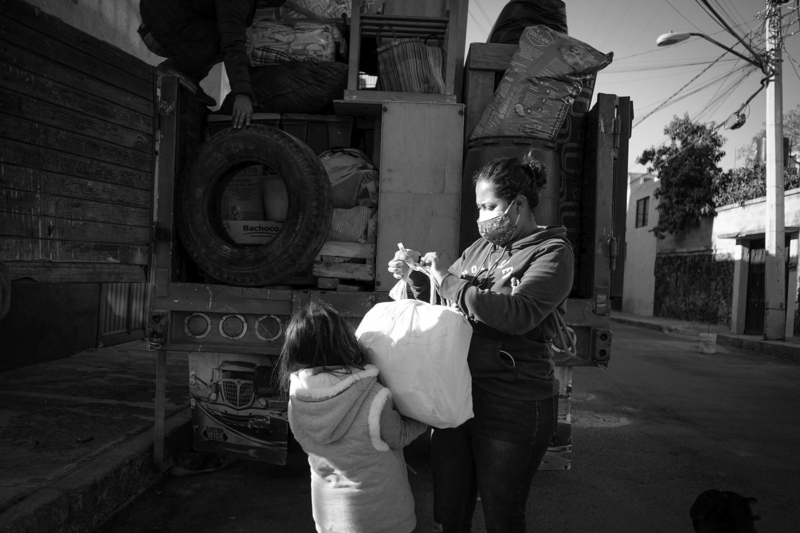 © Greta Rico - Team work. Nicole helps Siomara carry bags and small packages for the seventh move in the last four years.