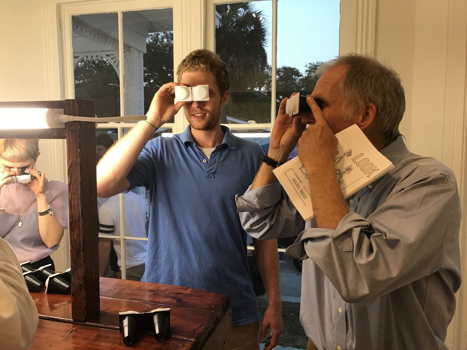 © RACHEL TREIDE - Visitors to 2019 exhibition "LOOK" that featured 31 of Treide's stereographs look through stereoscopes