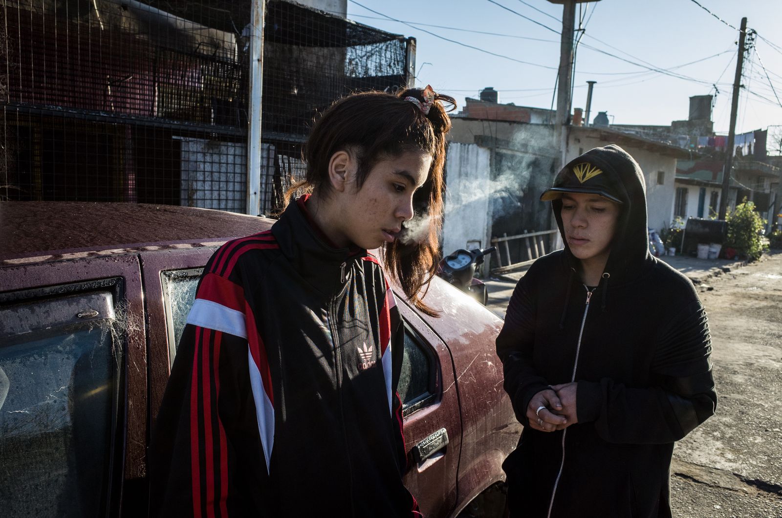 © Karl Mancini - Buenos Aires, Isla Maciel. K. and F. warm up by smoking on a cold morning after a night spent on the street.