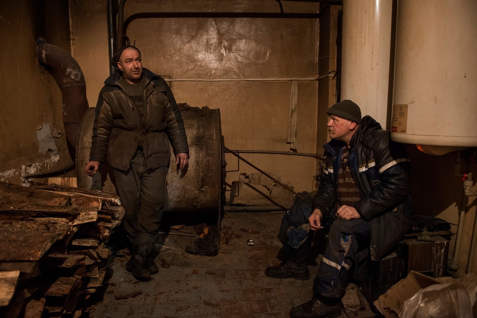 © Pierpaolo Mittica - resting room for the workers. Alexander and Pavel while warming themselves close to the heating system