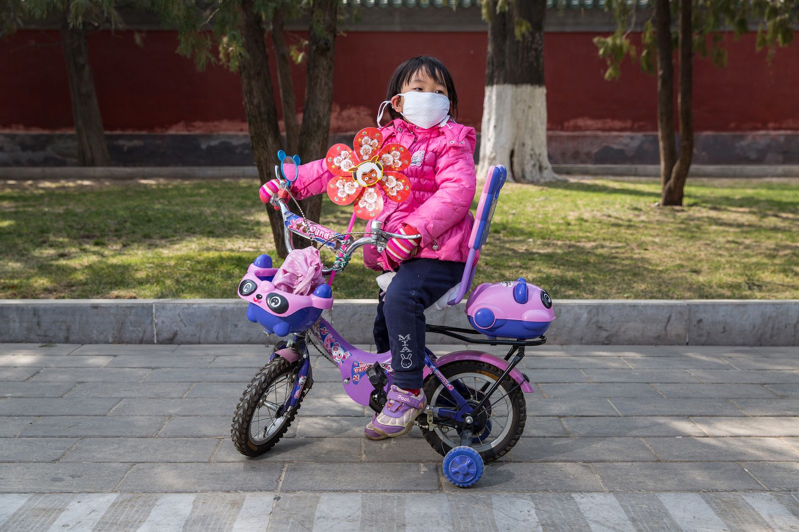 © Sean Gallagher - A young girl pauses for a moment while riding her bike through Beijing's Ditan Park.