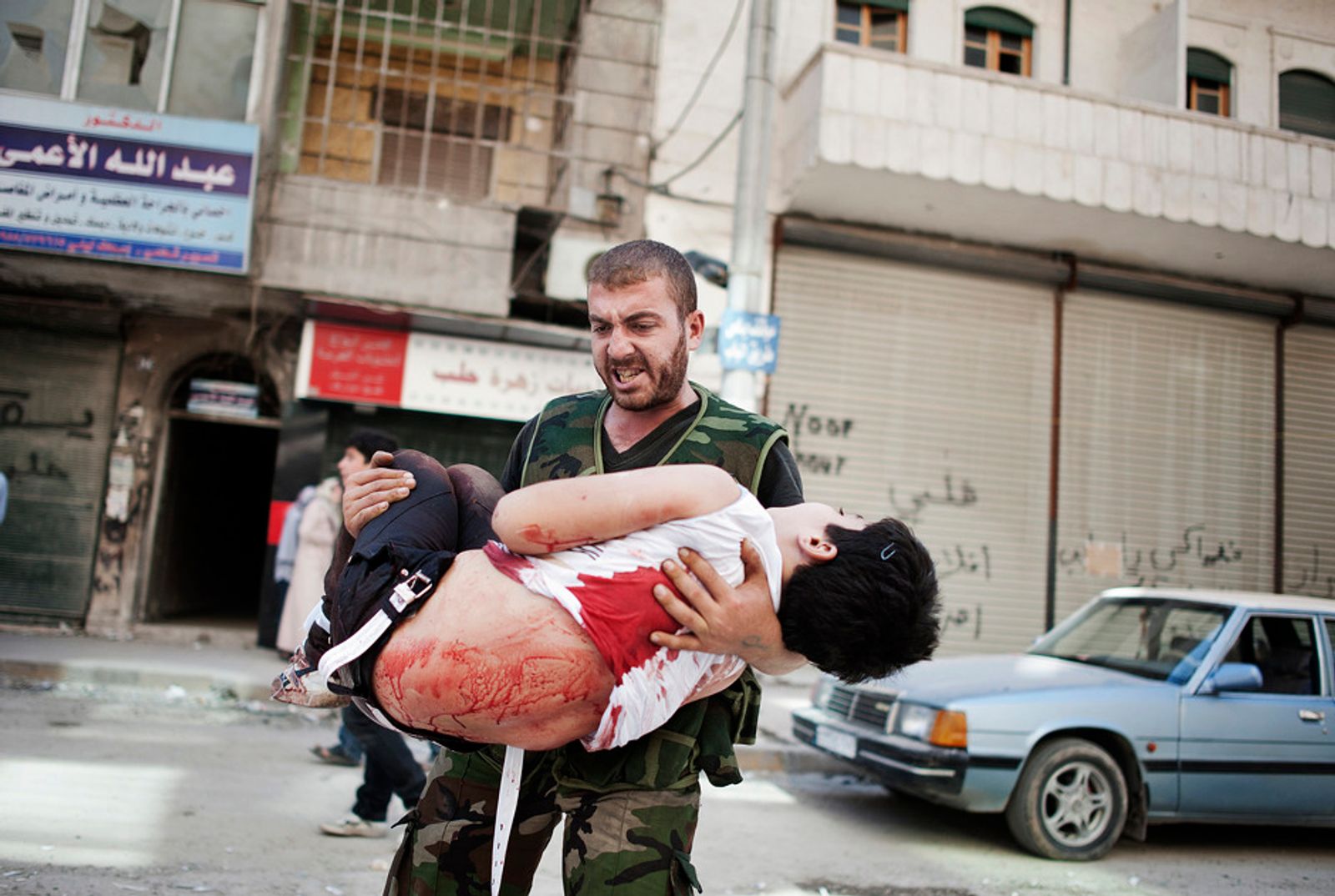 © Giulio Piscitelli - Syria, Aleppo - September 21, 2012 - Rebel carries the body of a child killed by bombs Ph.Giulio Piscitelli