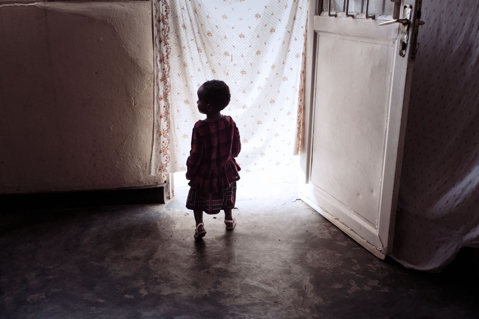 © Carol Allen Storey - Ornella’s daughter Ashimwe plays a game of hide and seek dashing in and out of their tidy small house.
