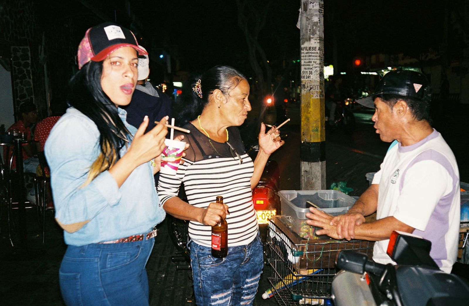 © Lisette Poole González - Liset (left) and Marta with a street vendor in Medellín, after going out and partying with local smugglers.