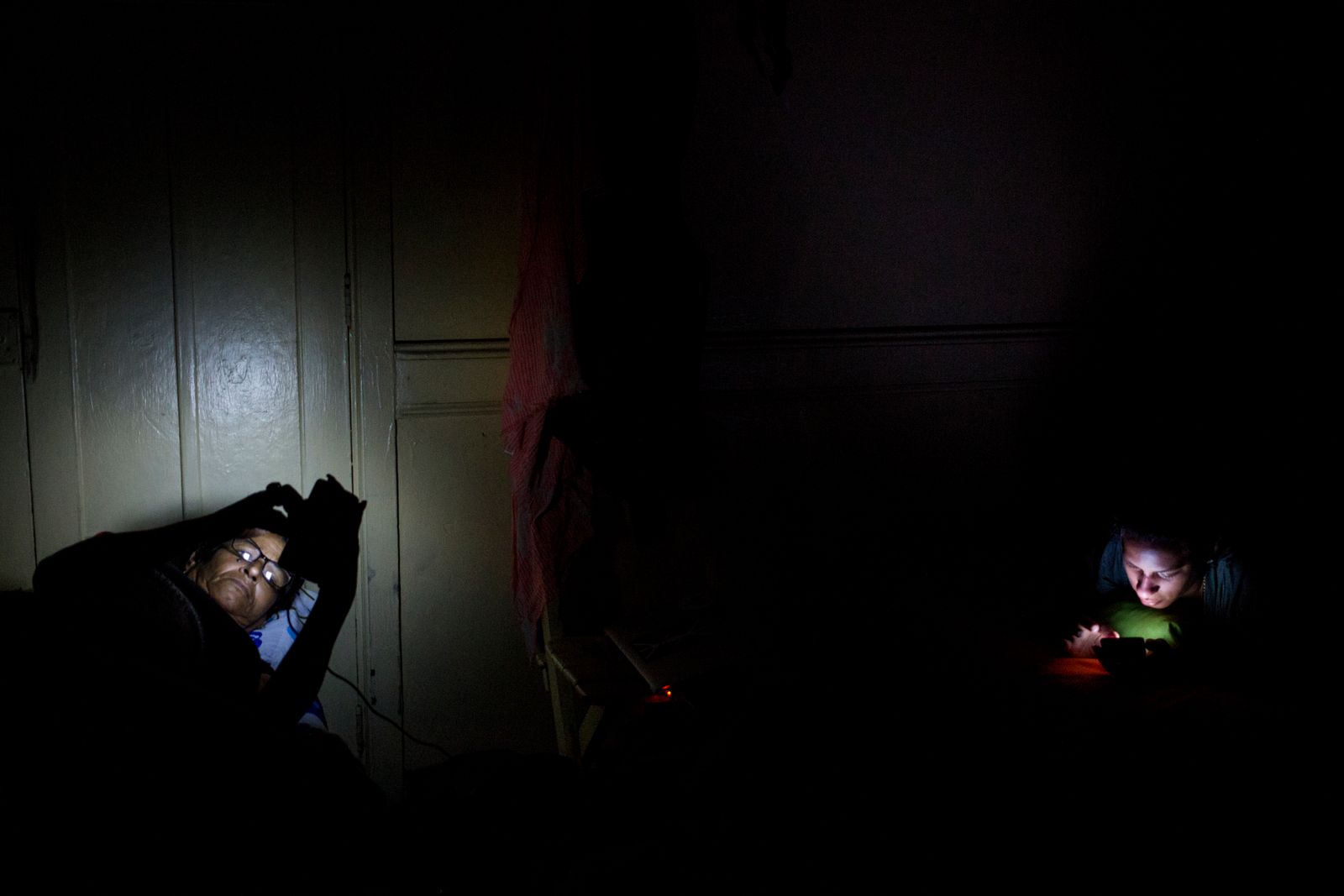 © Lisette Poole González - Marta and Liset (right) check their phones after arriving in Lima before dawn.