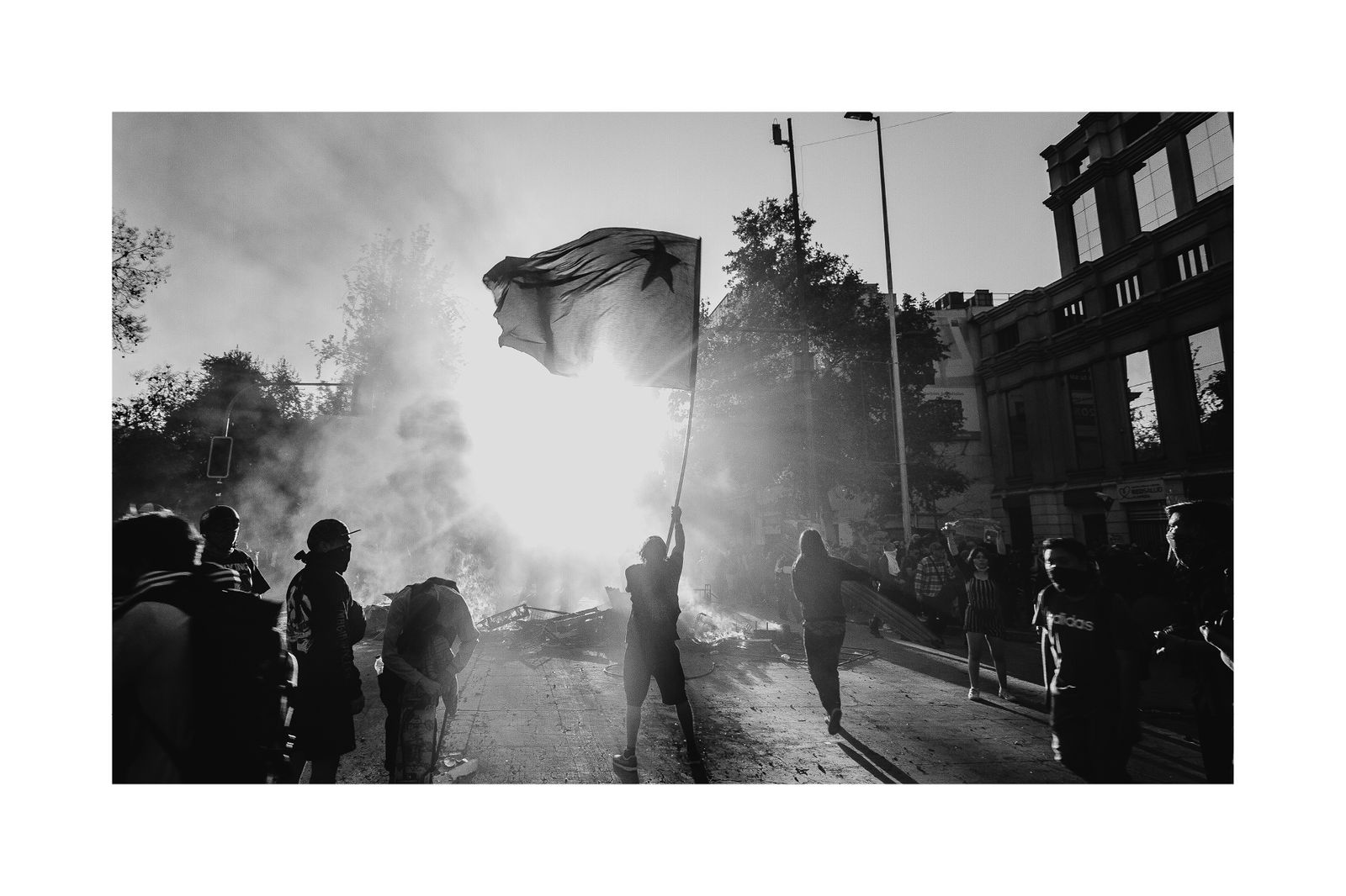 © Matias Cortez - A demonstrator rises a black Chilean flag