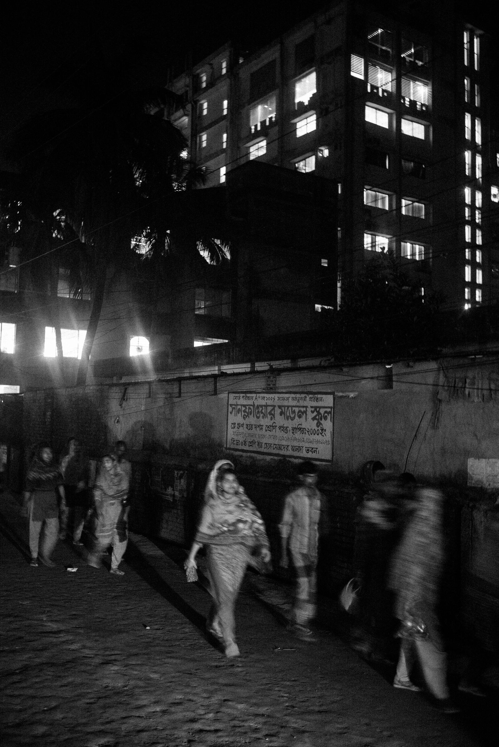 © Jost Franko - Garment workers leave the factory (in the back) after their shift in Dhaka, Bangladesh, on March 9th 2016.