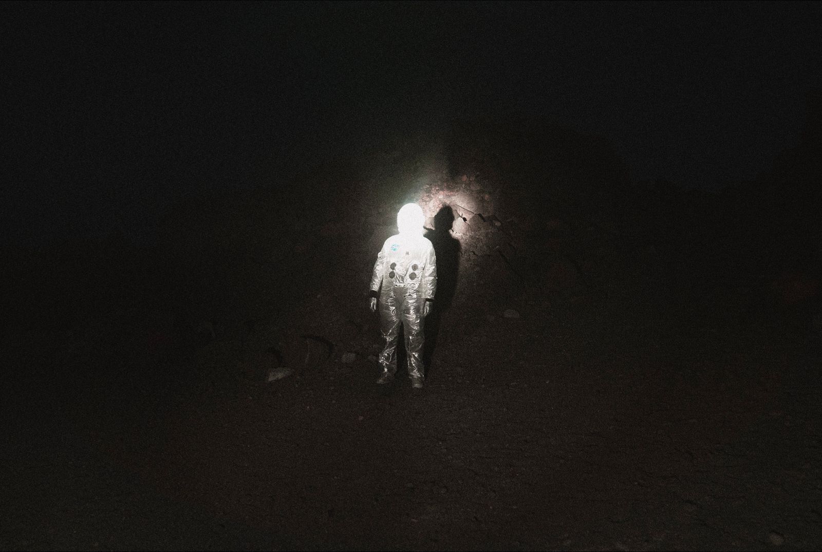 © Mackenzie Calle - I staged an image of a queer person in an astronaut suit with a beam of light, a target, on them.