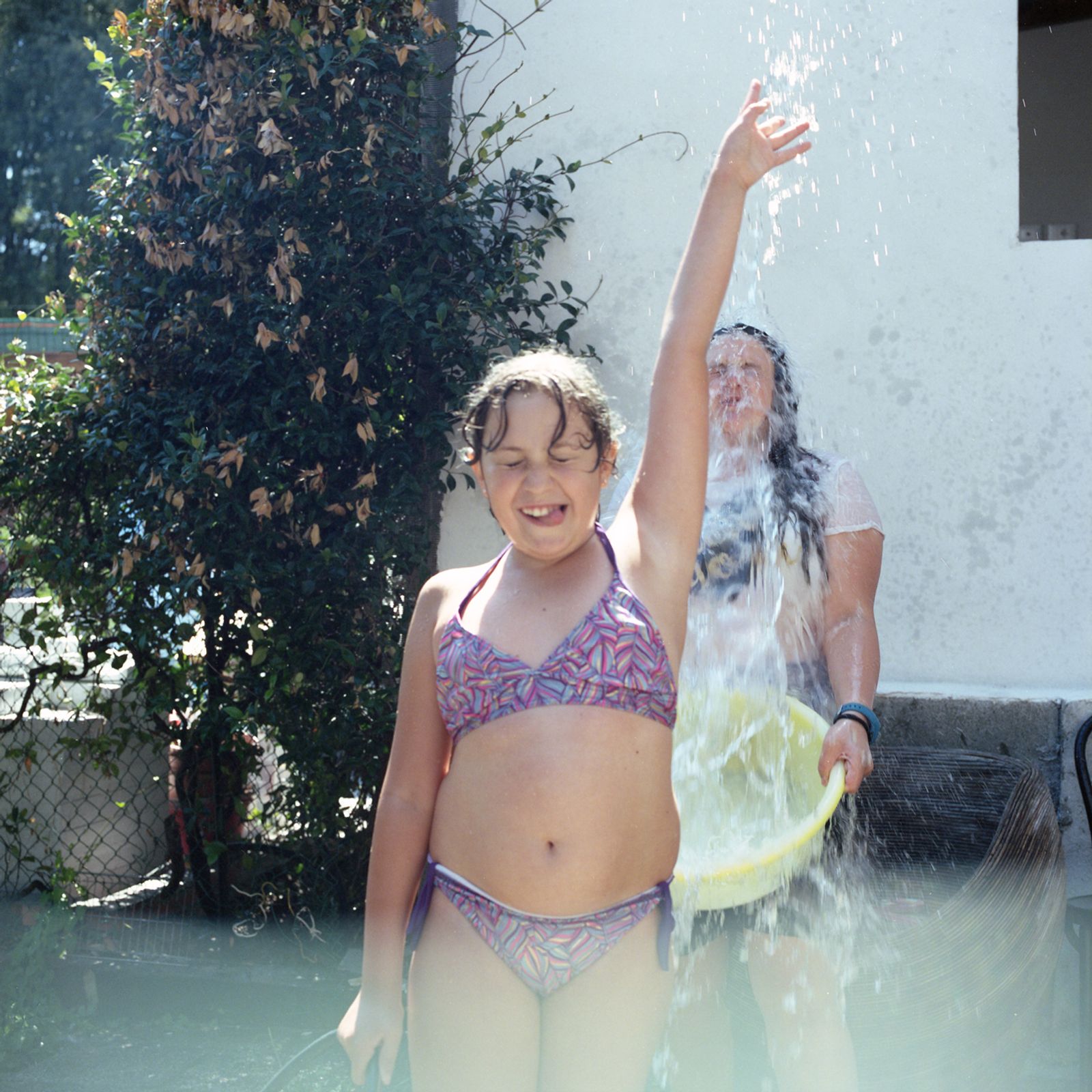© Chiara Fossati - Alessandra and her sister Martina playing with water on a hot summer day