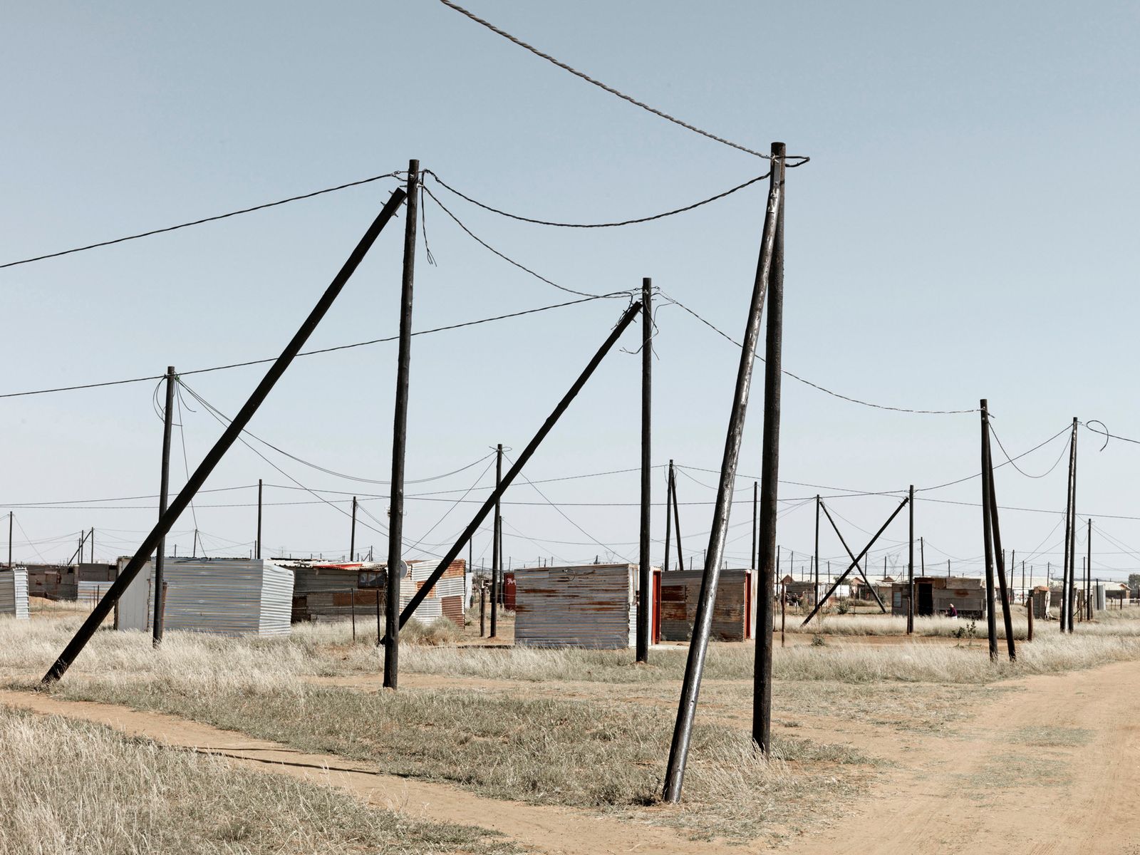 © Graeme Williams - Delareyville, South Africa. 2013. New shack dwellings receive electricity from the state.