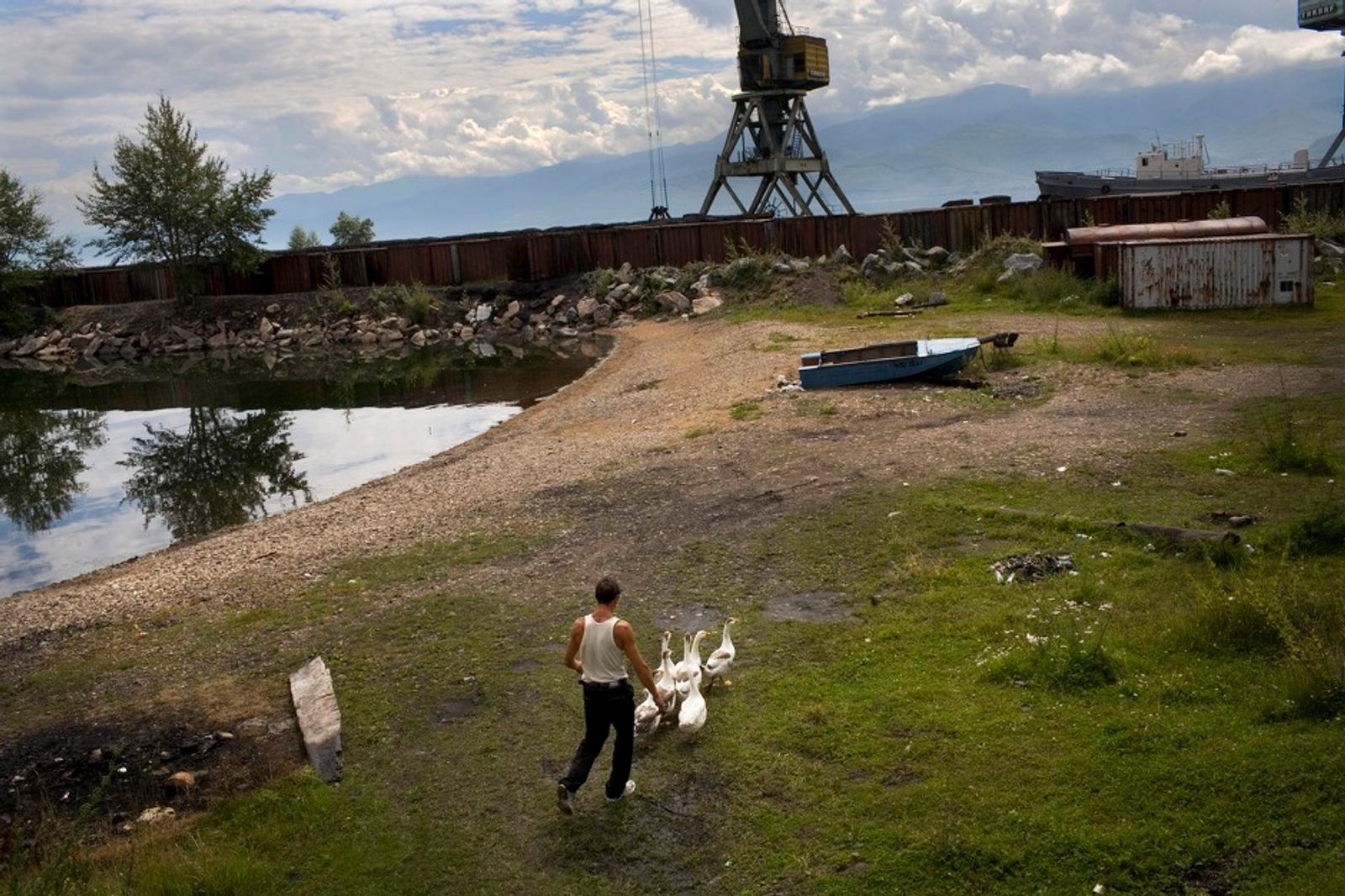 © Marco Pighin - Kultuk, Irkutsk Oblast, Russia. August 2010. A man running back his gooses.