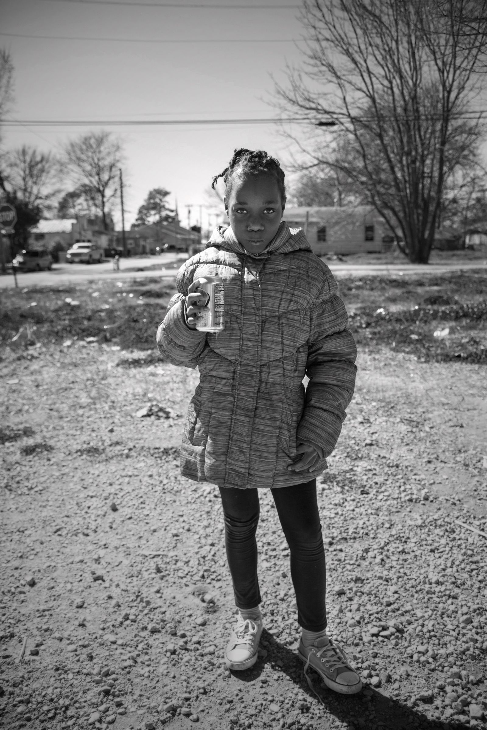 © Rebecca Moseman - Girl with Soda Can. A young girl plays outside of her shotgun house within Baptist Town, Mississippi.