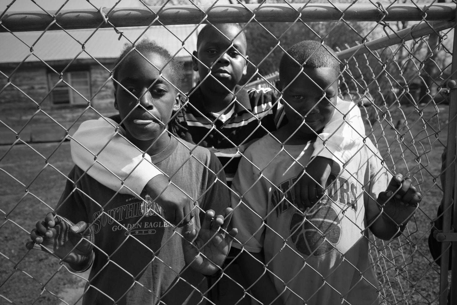 © Rebecca Moseman - Protected. A group of boys from Greenville, Mississippi run behind a fence for protection from a drive by shooting.