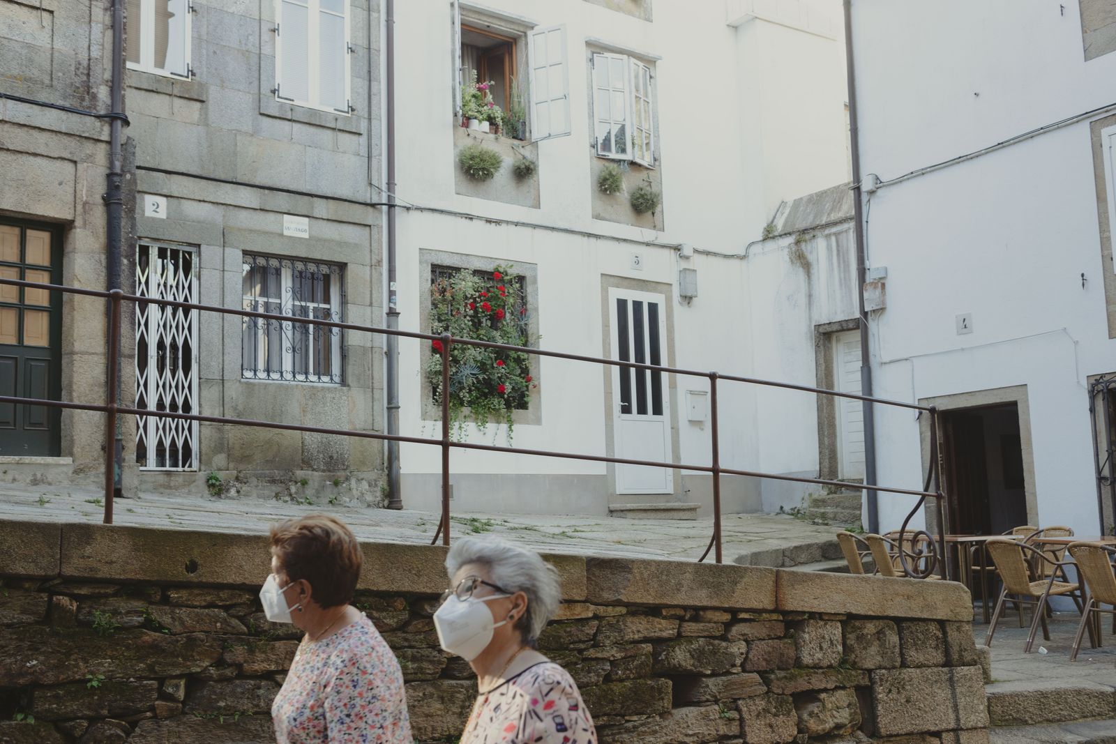 © Ana Norman Bermudez - Two local women walk through Santiago's alleyways wearing medical masks.