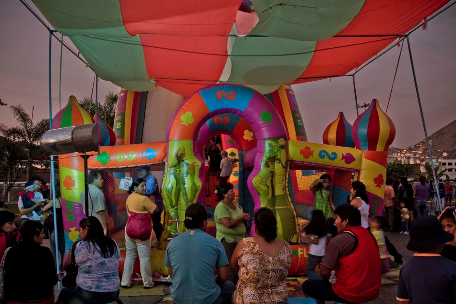 © Max Cabello Orcasitas - Parents wait for their children while they have fun in a inflatable slide. Lima.