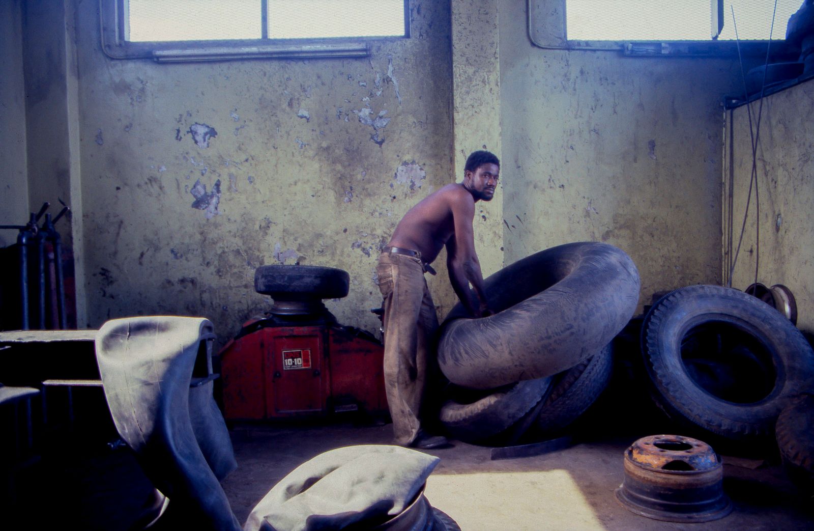 © Steven Edson - Man repairing a inner tube at a tire repair shop. Jamaica