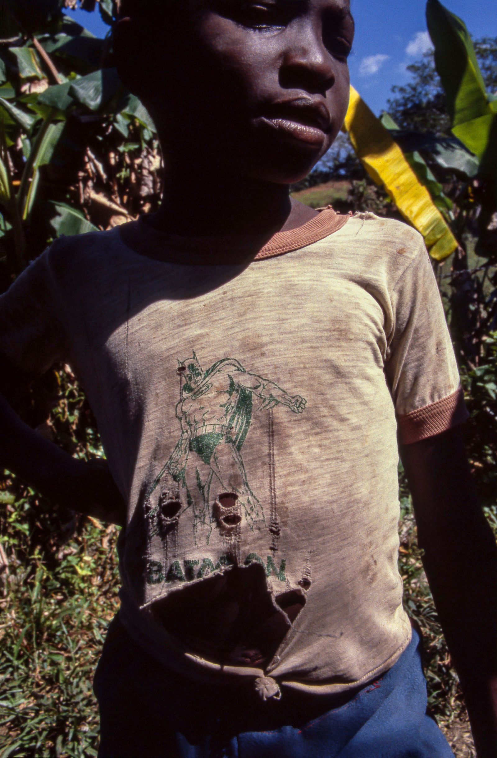 © Steven Edson - Portrait of a boy with tattered Batman t-shirt. Jamaica