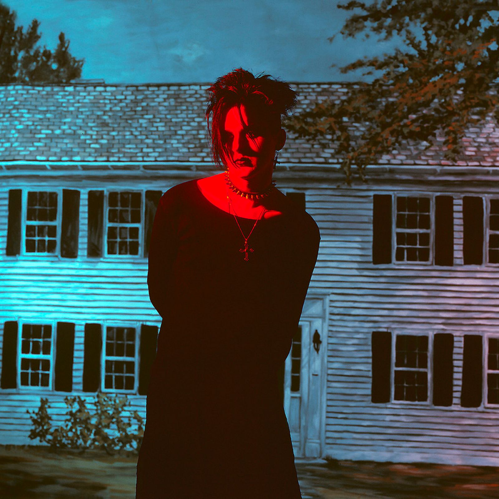 © Steven Edson - Goth man bathed in red light in front of house