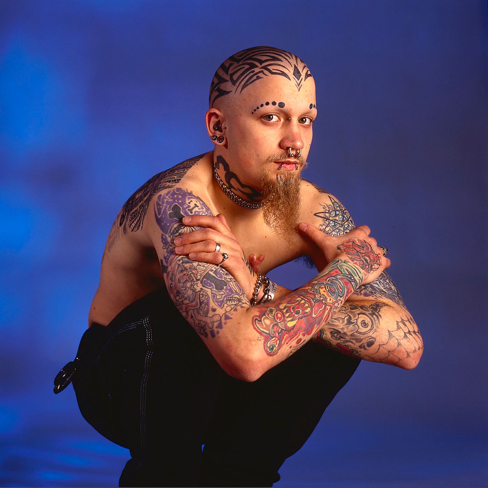 © Steven Edson - Young man with beard has many tattoo's and piercings across his body.