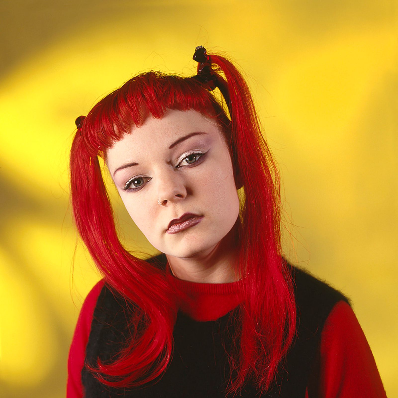 © Steven Edson - Young woman with bright red hair against a yellow background