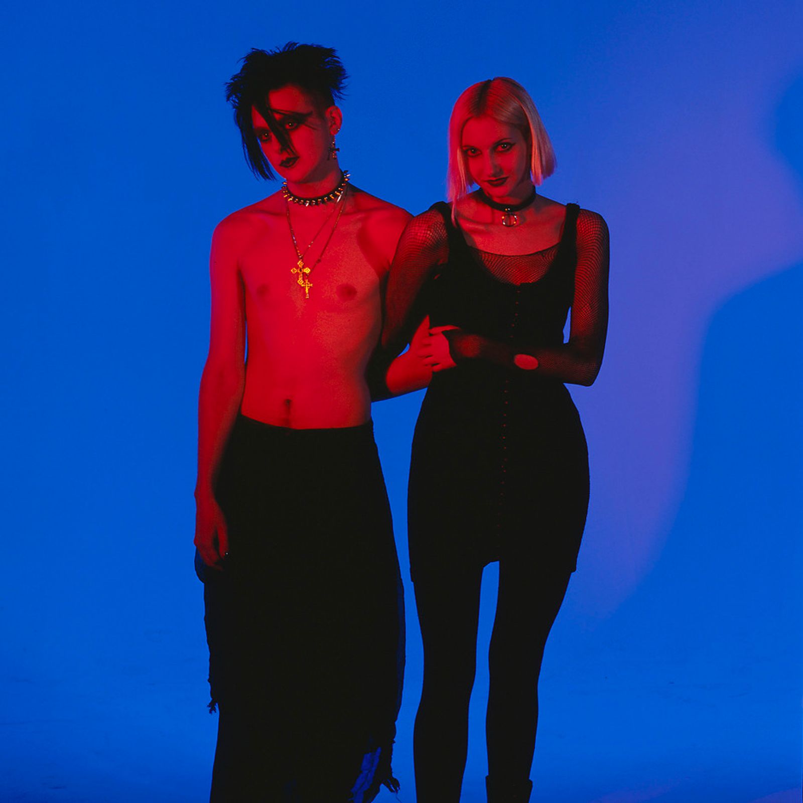 © Steven Edson - Portrait of Goth couple in red light against a blue background
