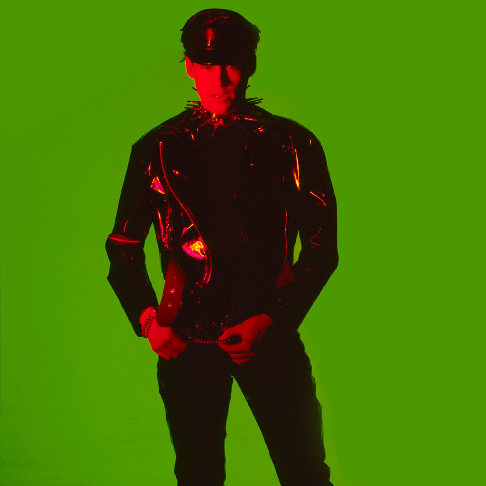 © Steven Edson - Young man in black vinyl outfit against rich green background