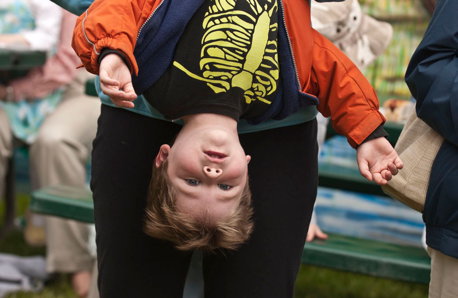 © Steven Edson - Young boy in costume is being held upside down by his father. Newton, MA