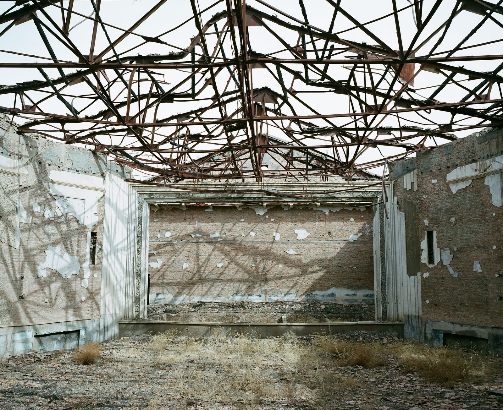 © Pan Wang - April 15, 2018，Yumen City, Gansu Province, China. Abandoned theater, leaving wrecked walls and exposed steel bars.