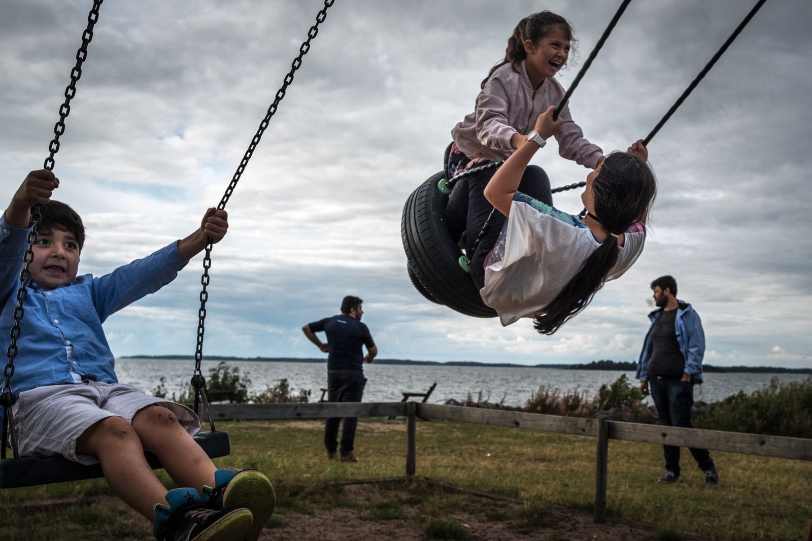 © Sergey Ponomarev - Kids of Ahmad and Farid Majid, background, swing at the park in Sweden.