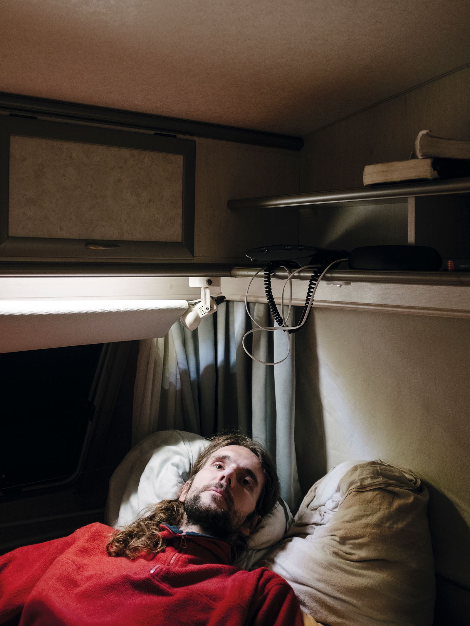 © Nick Somers - 'R' in the caravan where he now lives after having to flee from his home.