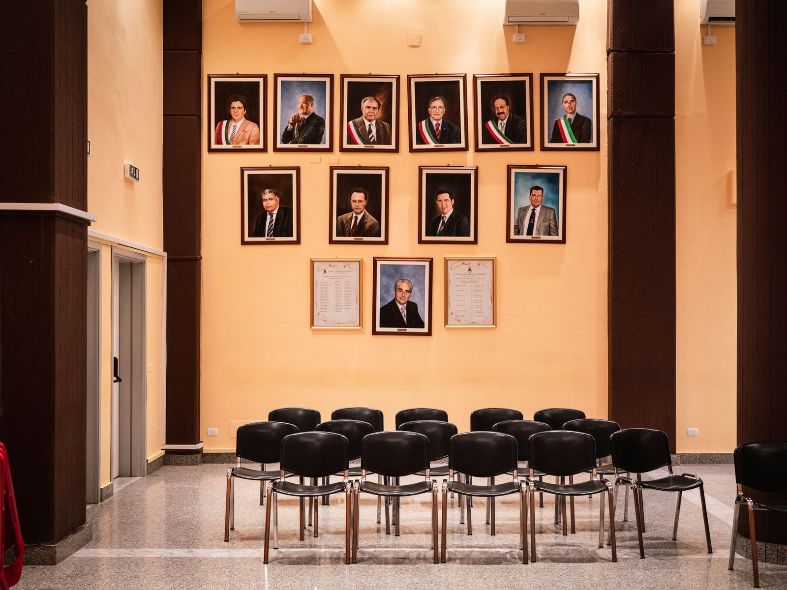 © Sebastian Wells - Paintings of all mayors are mounted on a wall of the local council. Priolo Gargallo, September 2019.