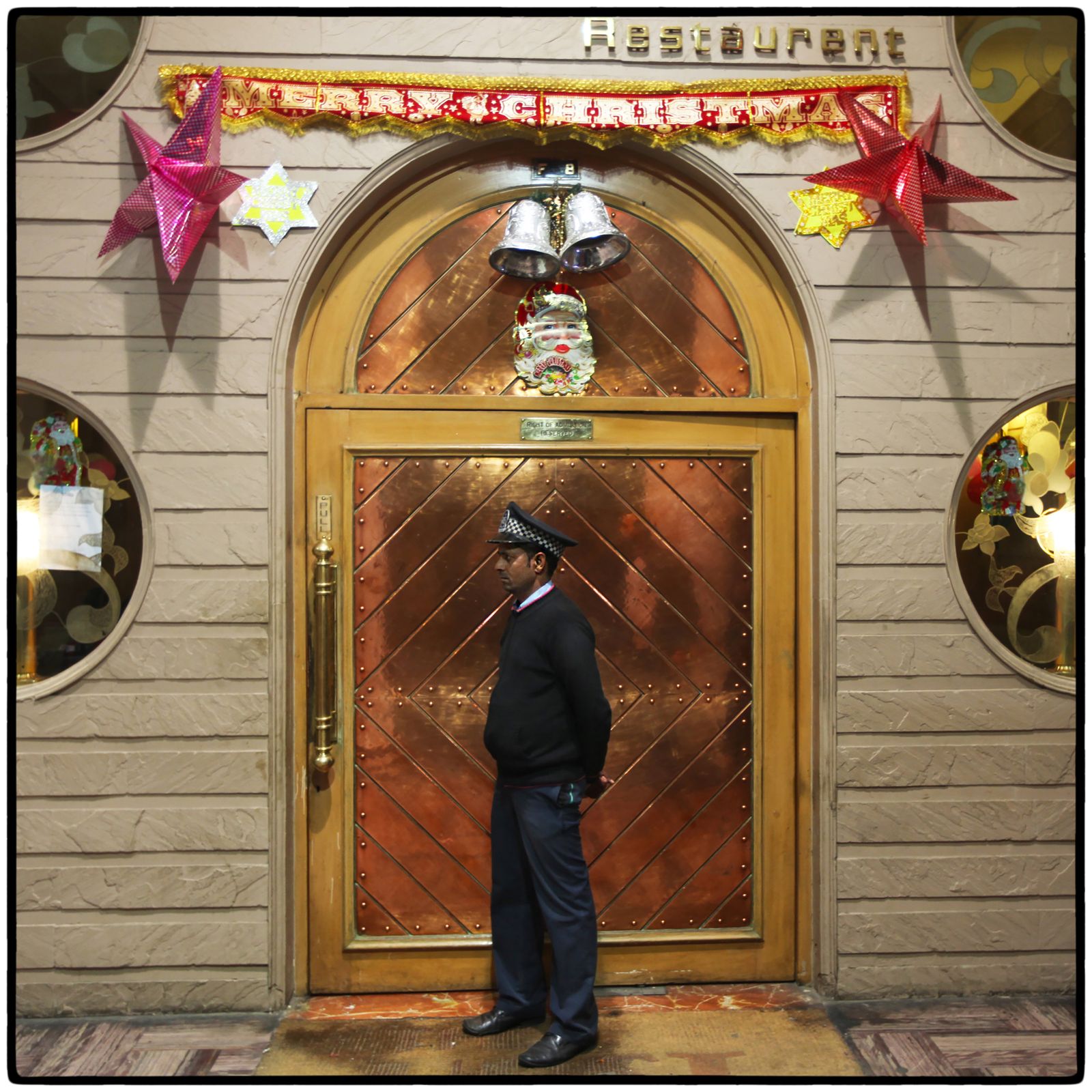 © Vijay S. Jodha - Doorman of an upscale restaurant decorated on Christmas in New Delhi's Connaught Place shopping district.