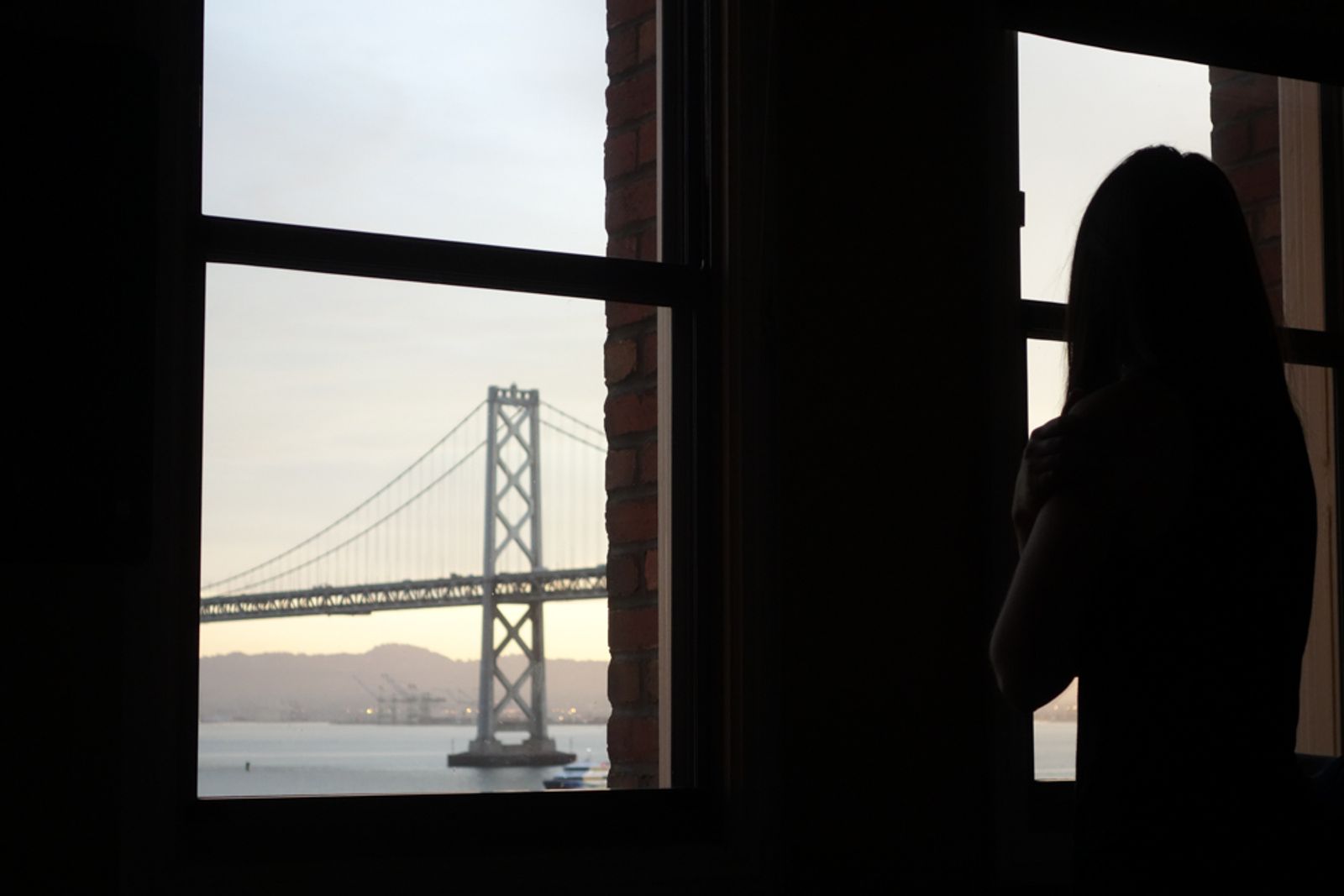 © Vincent Dupont-Blackshaw - Bay Bridge: One morning in San Fransisco, a traveller look at the Bay Bridge through the her hotel room's window