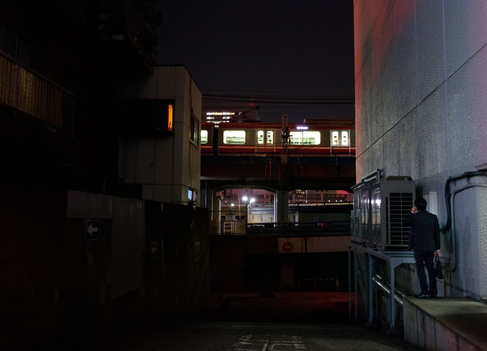 © Vincent Dupont-Blackshaw - Last man standing. A man takes a call in a back street of Tokyo, next to the subway.
