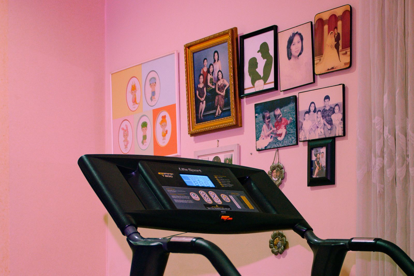 © Hafitz Maulana - Hartanto's family portraits are hung on the wall next to the treadmill sports tool.