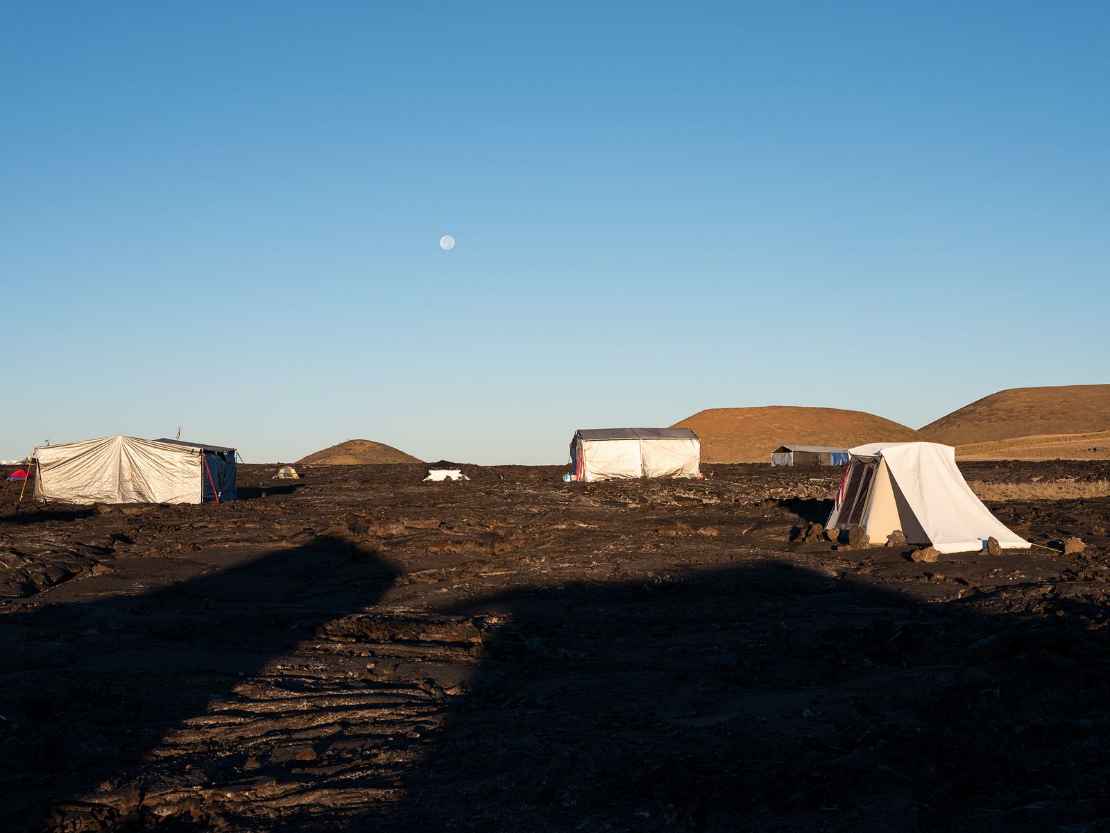 © Molly Peters - The full moon sets shortly after sunrise in the camp.