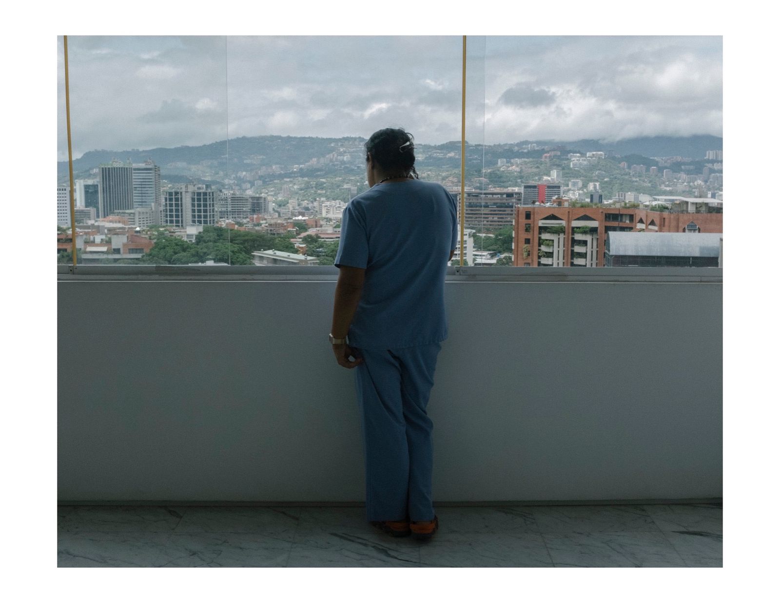 © Andrea Hernández Briceño - A house maid looks at the view in Caracas, Venezuela, on August 3, 2018