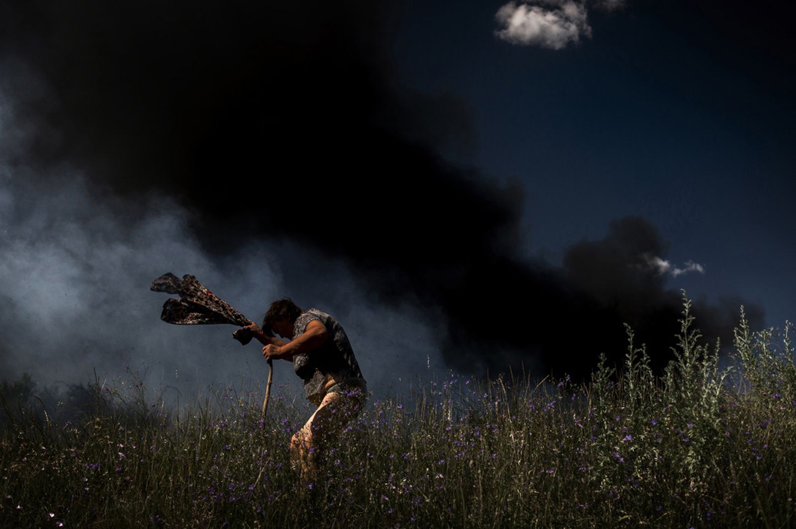 © Valery Melnikov - A woman escapes from a fire during an artillery attack in Krasnodon highway